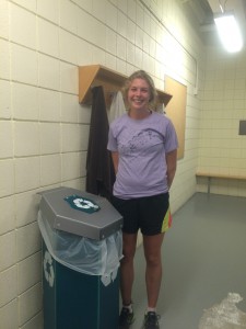 Cross Country runner Eliza Matt stands next to one of the new locker room recycling bins