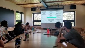 Students listen to a presentation in a light-colored classroom