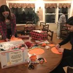 Two people working on crafts around a kitchen table