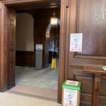 Mask recycling box stands in front of dark wood paneling