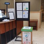 Mask recycling bin in front of Driscoll menu poster
