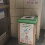 Mask recycling bin in front of tiled wall