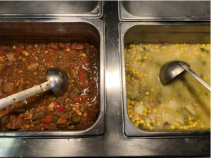 Two different kinds of soup being served by the dining hall; one appears to be corn chowder