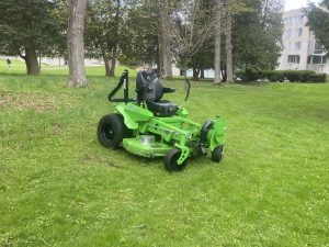 Image of a green electric lawn mower parked on short grass