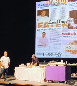 Chef Jet Li at Annual Dining training on stage in front of screen with newspaper articles of him