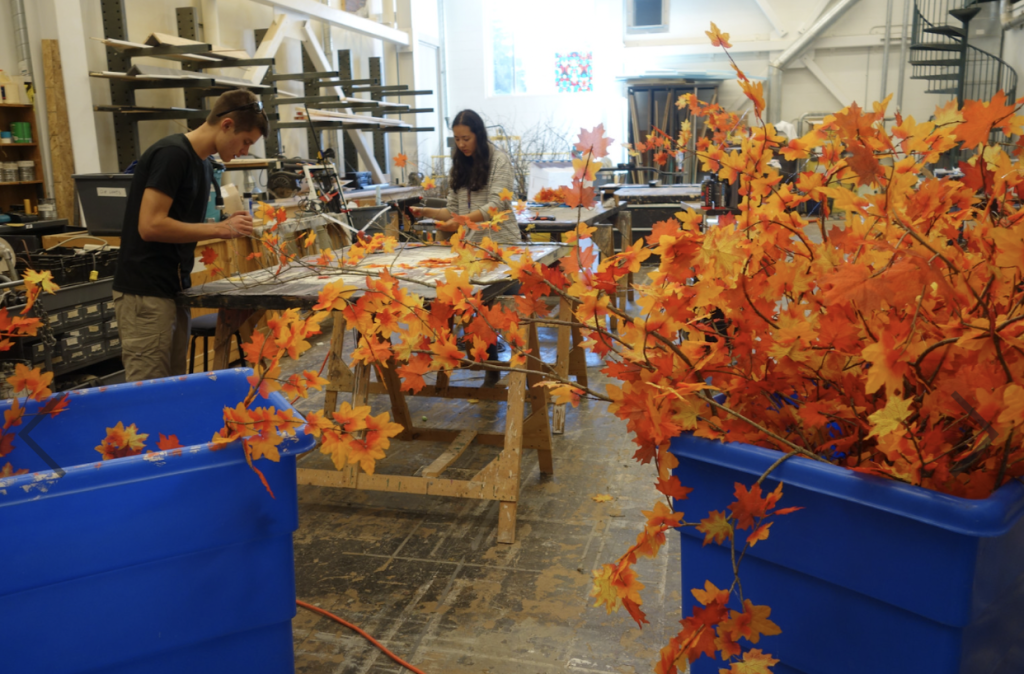 Students making set design of orange leaves