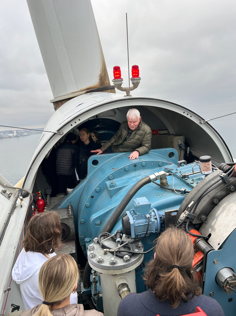 students examining wind turbines mechanics, led by professor
